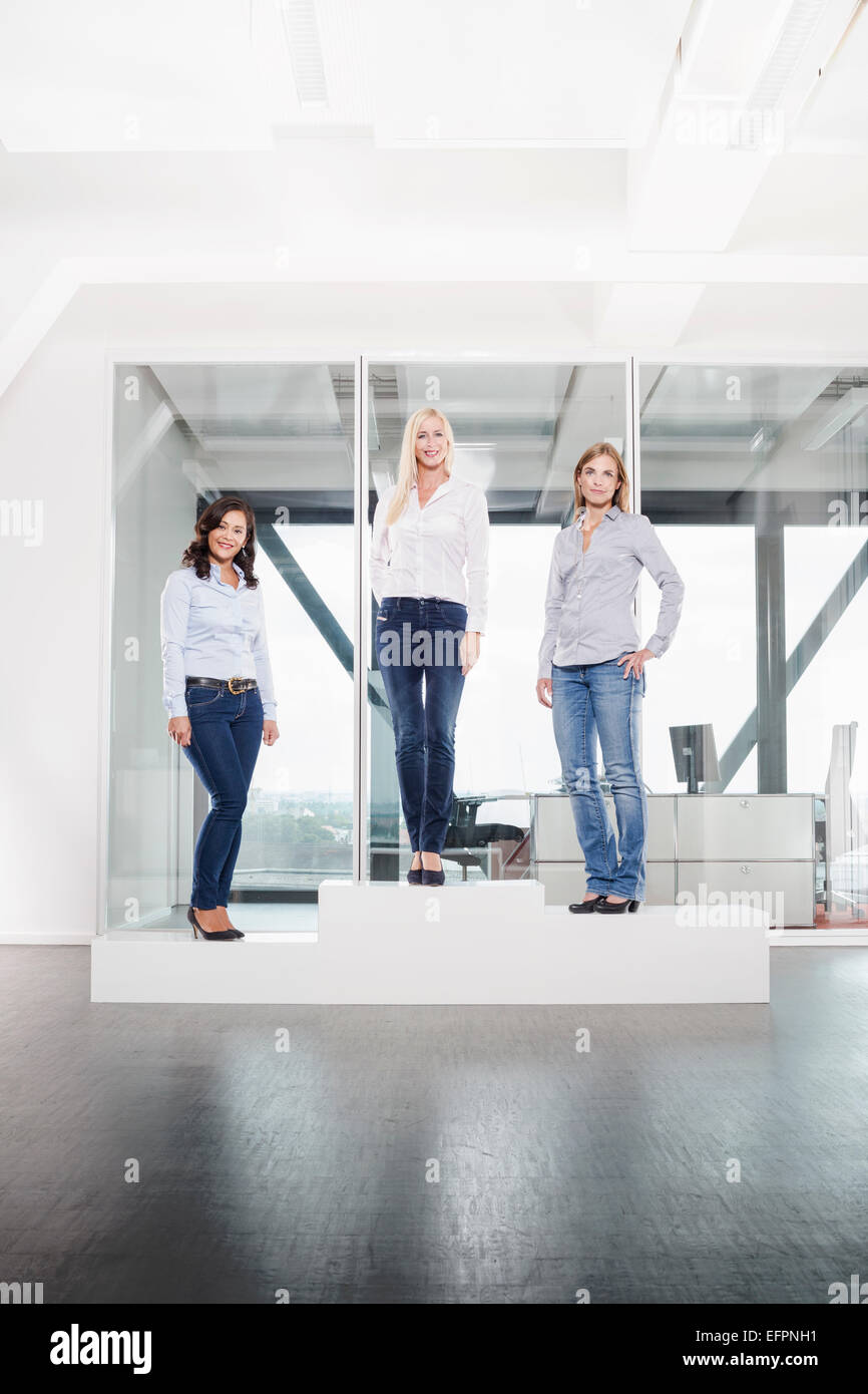 Drei Frauen im Büro auf Podest Stockfoto