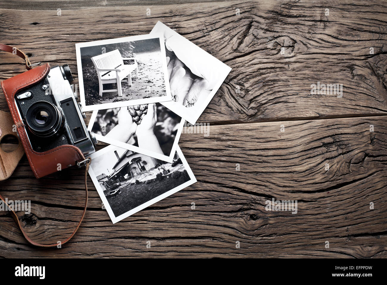 Alten Entfernungsmesser Kamera und schwarz-weiß-Fotos auf dem alten Holztisch. Stockfoto