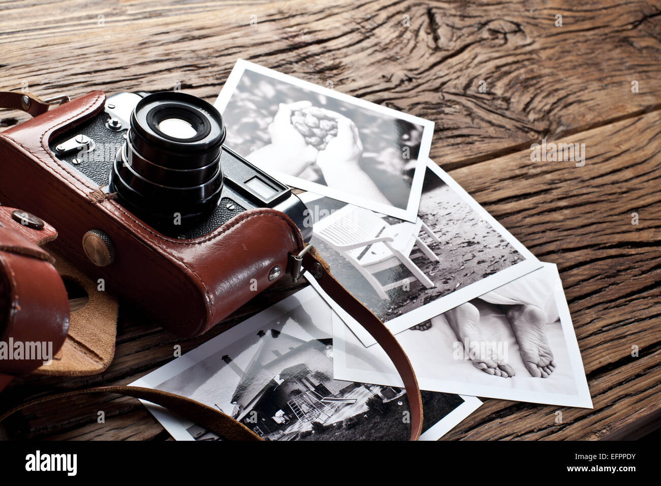 Alten Entfernungsmesser Kamera und schwarz-weiß-Fotos auf dem alten Holztisch. Stockfoto