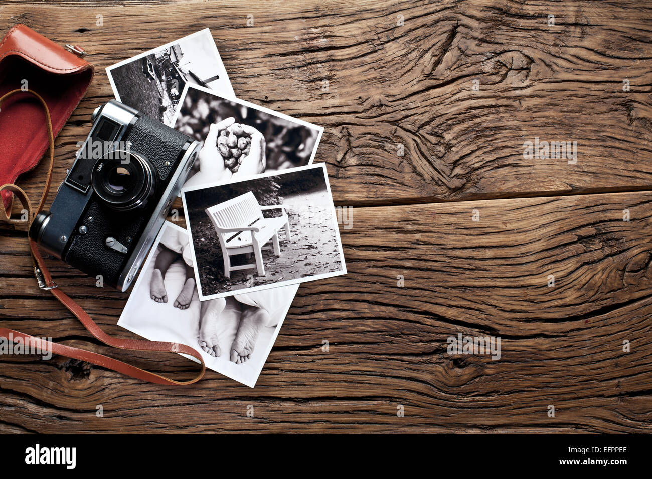 Alten Entfernungsmesser Kamera und schwarz-weiß-Fotos auf dem alten Holztisch. Stockfoto