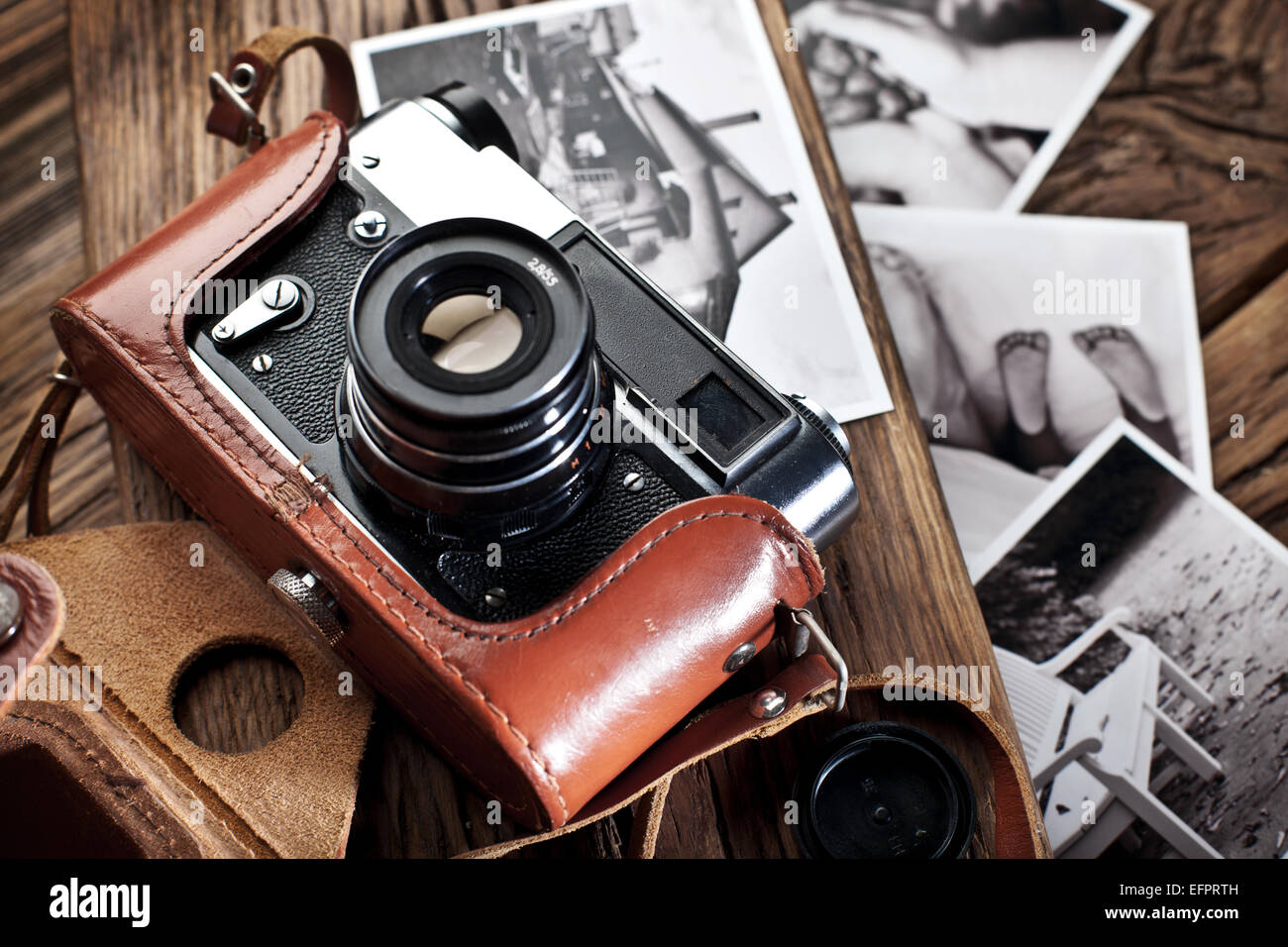 Alten Entfernungsmesser Kamera und schwarz-weiß-Fotos auf dem alten Holztisch. Stockfoto