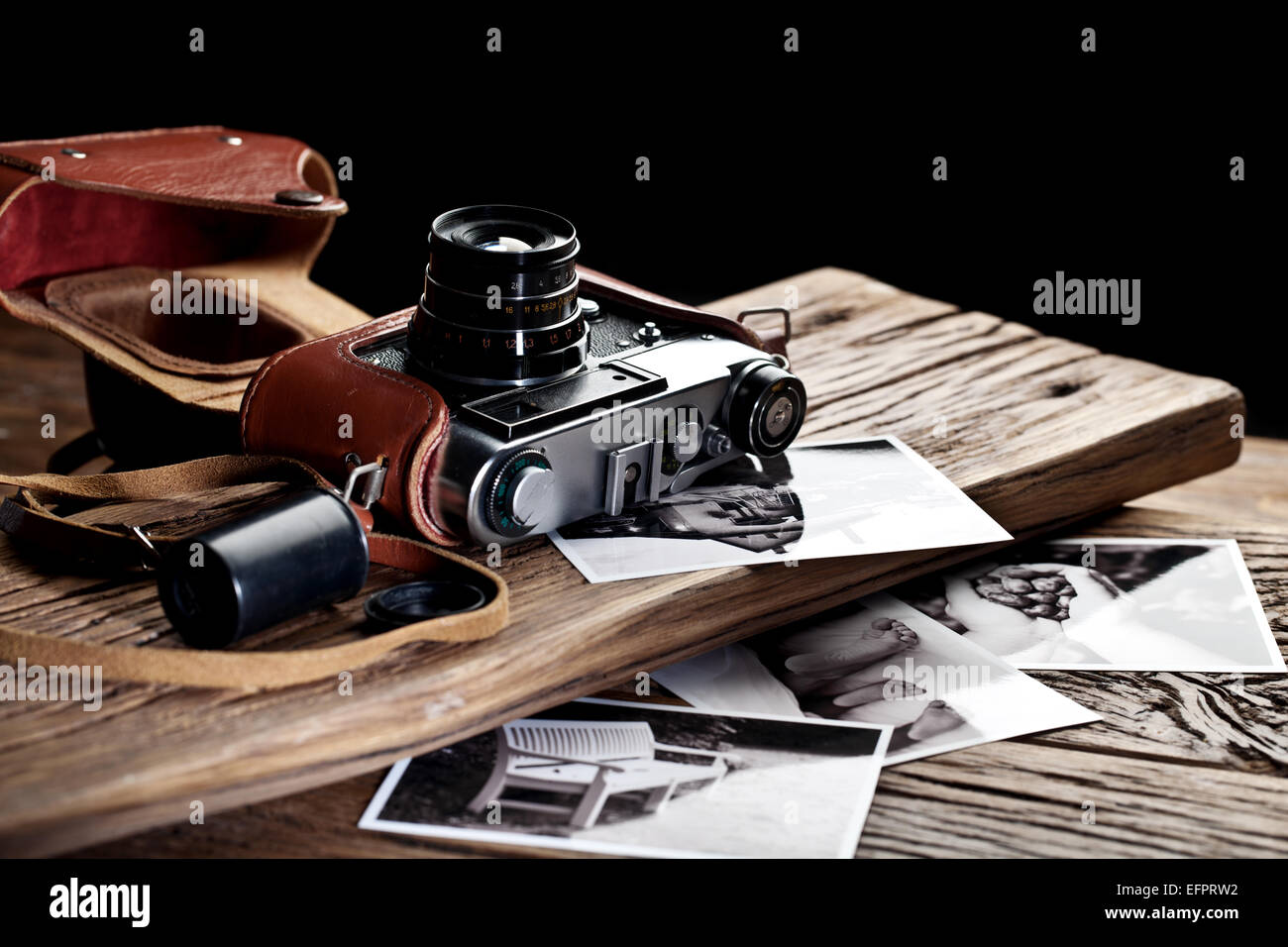 Alten Entfernungsmesser Kamera und schwarz-weiß-Fotos auf dem alten Holztisch. Stockfoto