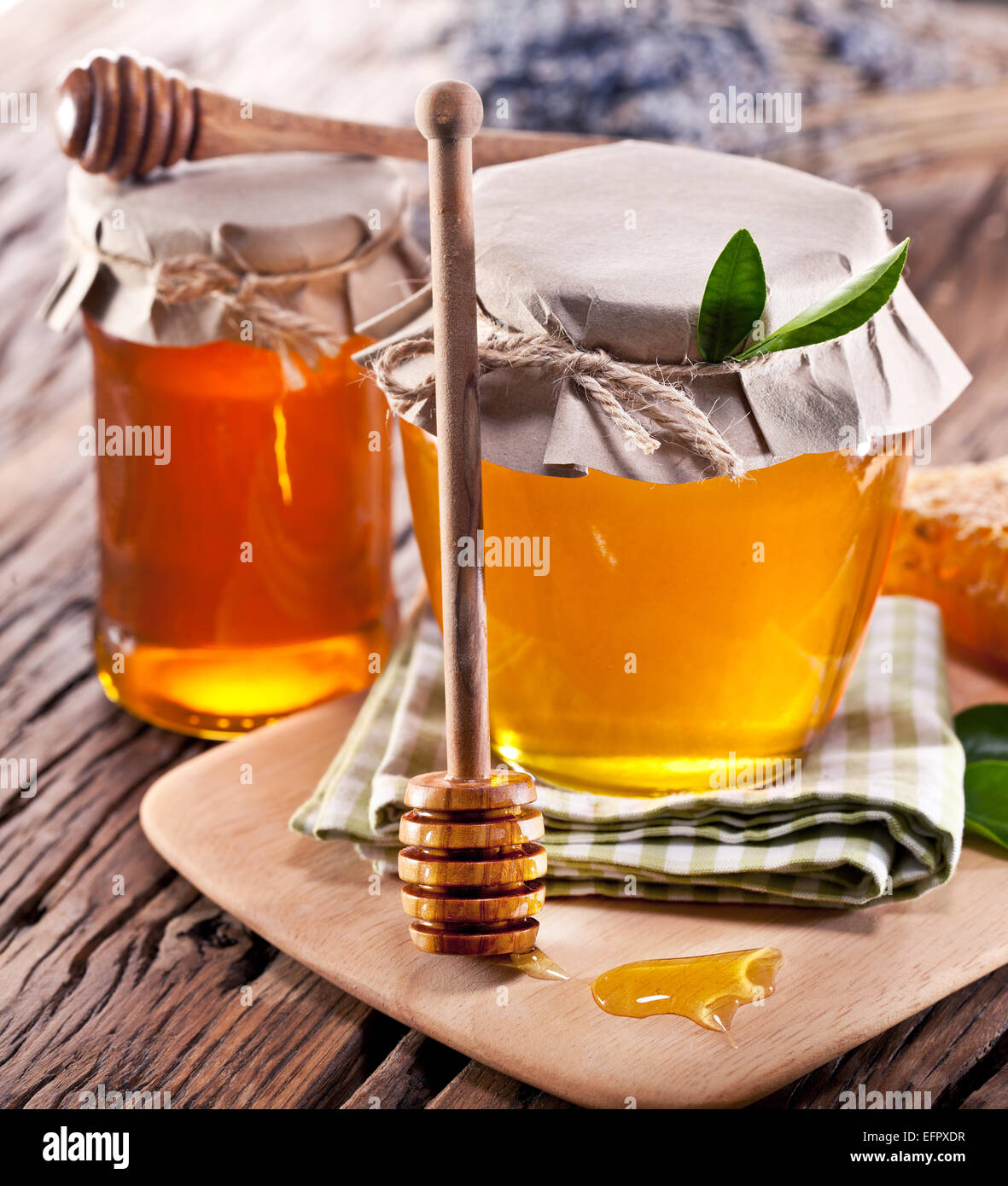 Glas-Dosen voller Honig auf alten Holztisch. Stockfoto