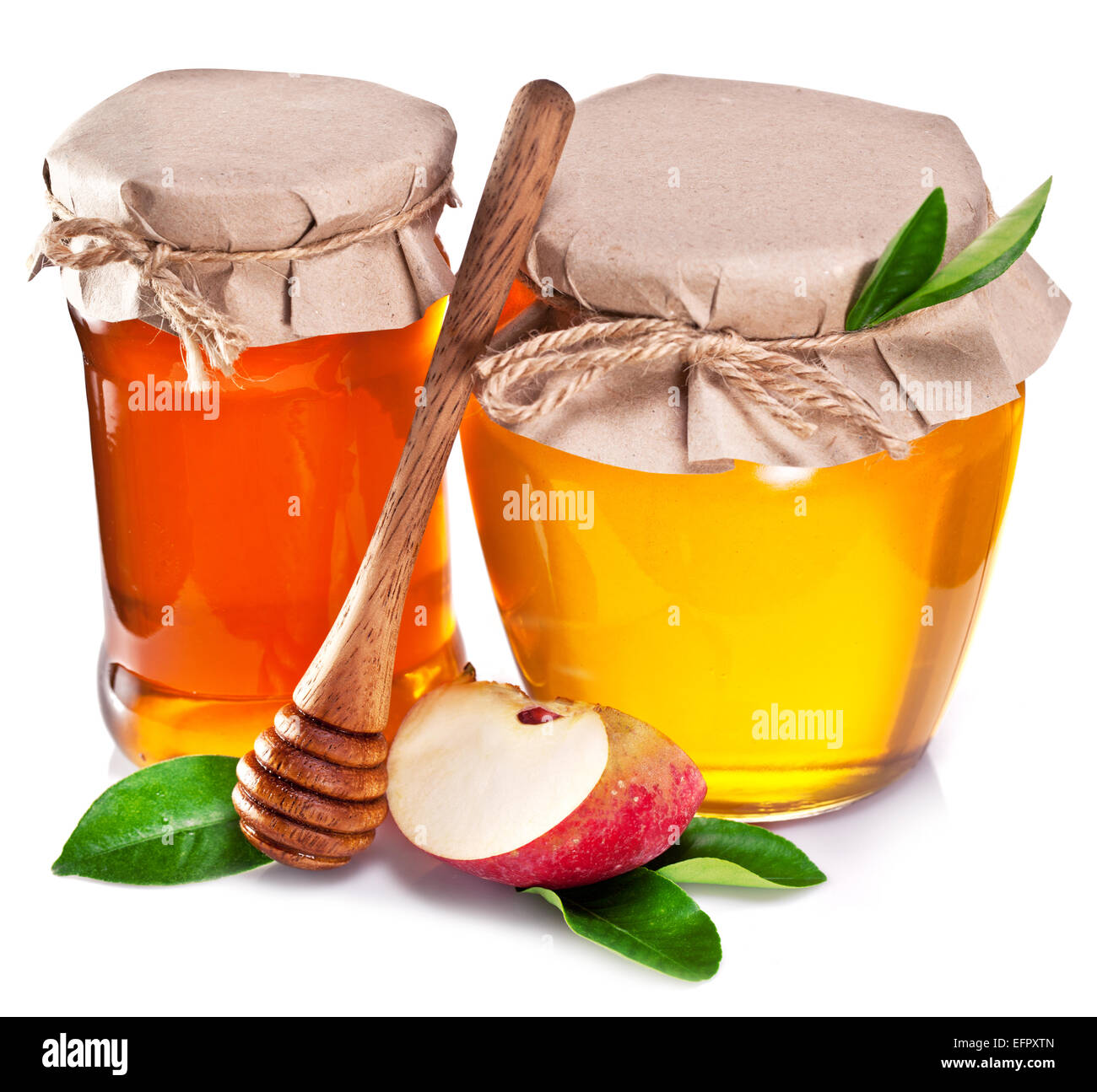 Glas-Dosen voller Honig und Apfel auf einem weißen Hintergrund. Stockfoto