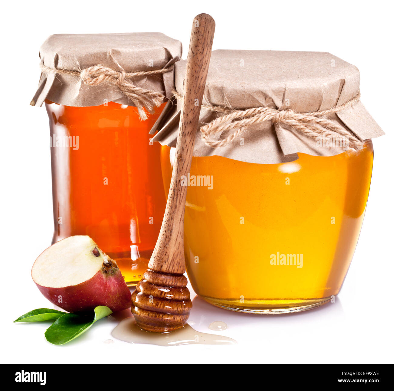 Glas-Dosen voller Honig und Apfelstück auf weißem Hintergrund. Stockfoto