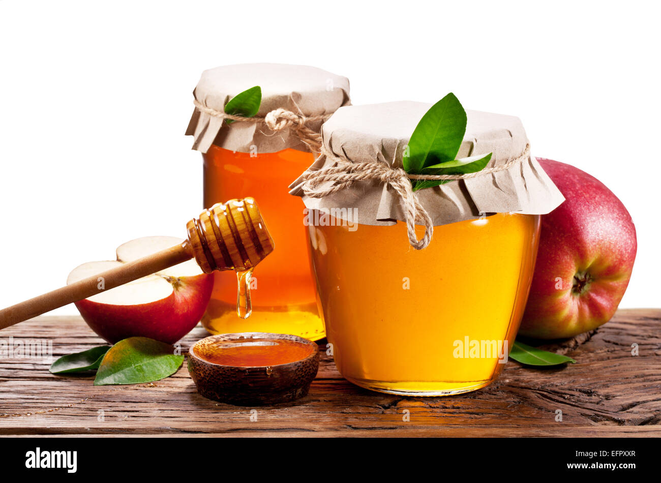 Glas-Dosen voller Honig, Äpfel auf alten Holztisch. Beschneidungspfade. Stockfoto