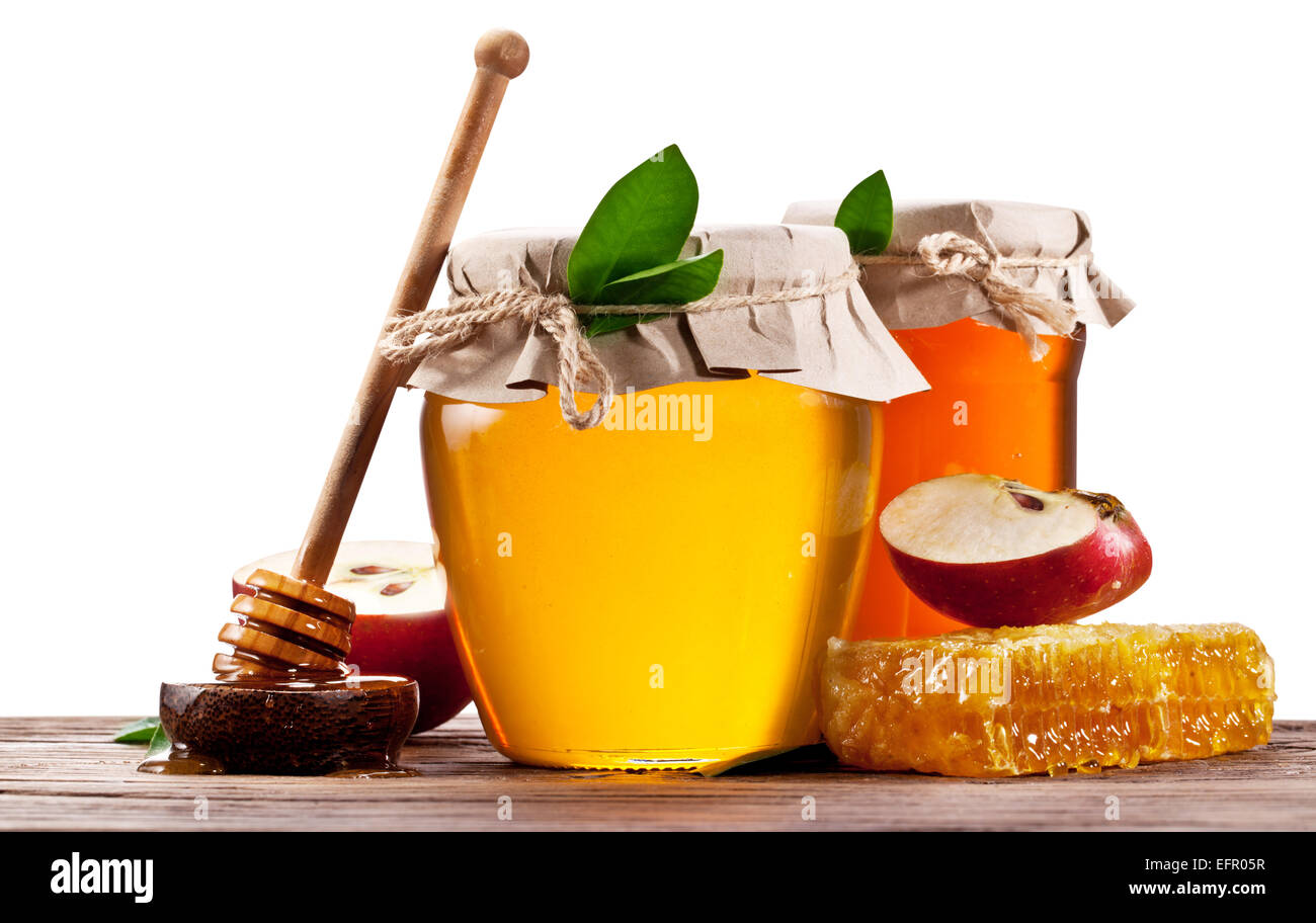 Glas-Dosen voller Honig, Äpfel und Waben auf Holz. Datei enthält Beschneidungspfade. Stockfoto