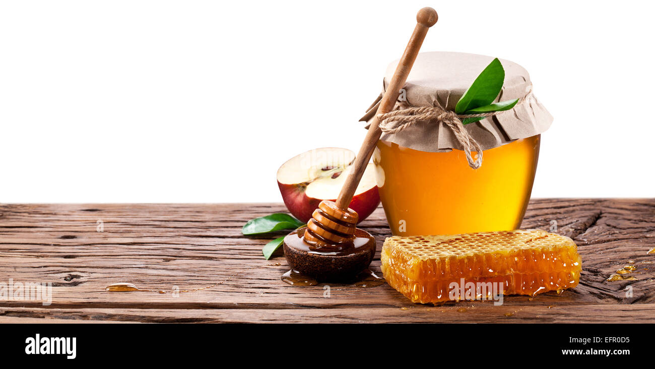 Glas kann voller Honig, Äpfel und auf alten Holztisch. Beschneidungspfade. Stockfoto
