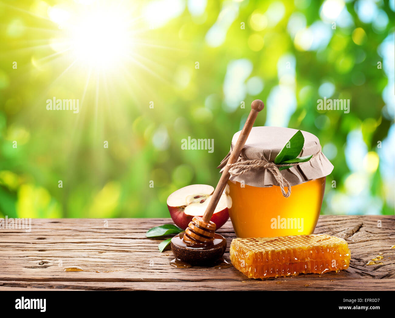 Glas kann voll von Honig, Apfel und Kämme auf Holztisch auf den Natur-Hintergrund. Stockfoto