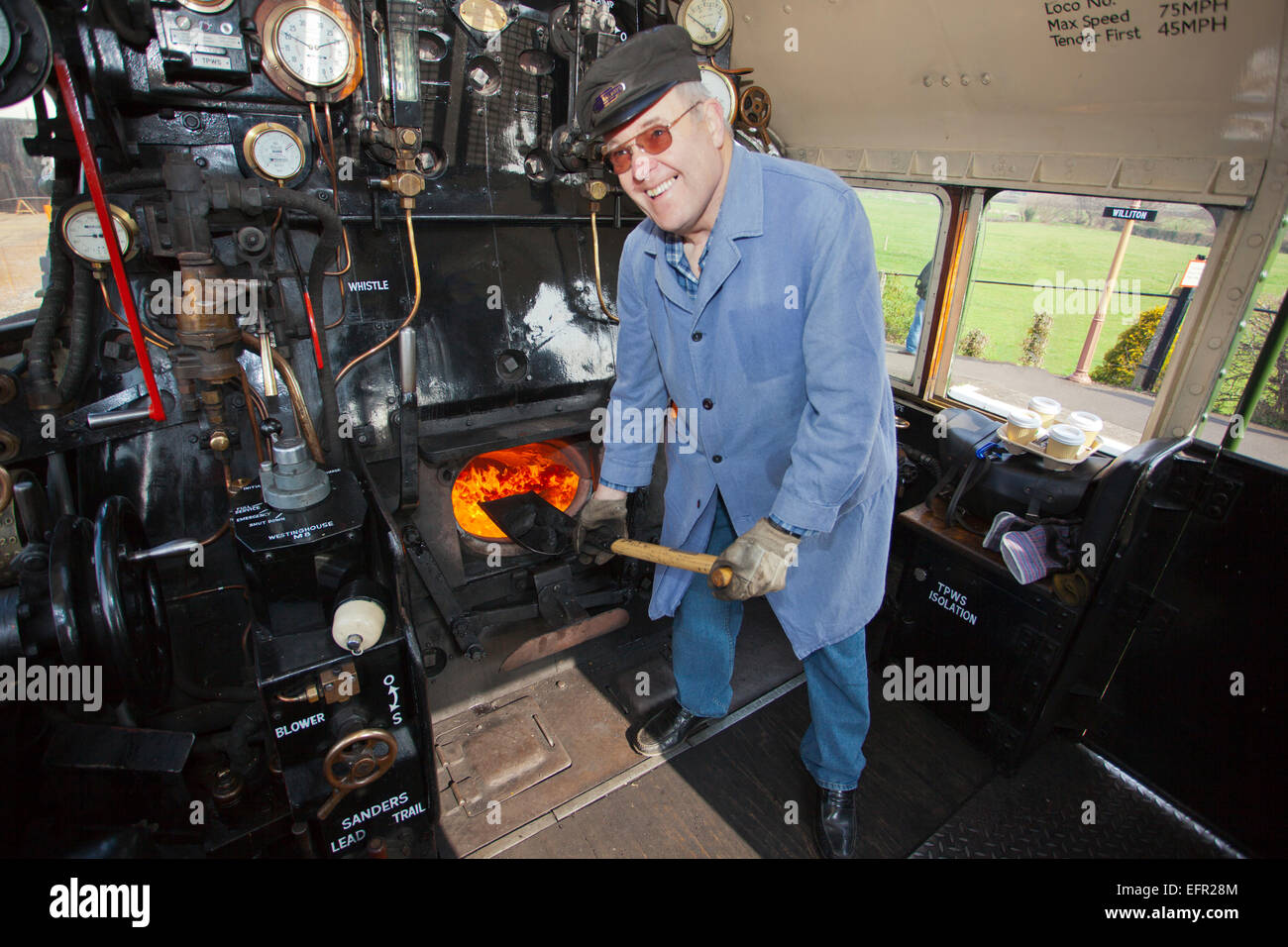 David Butcher feuern ein Ex-BR express Lok Nr. 70000 "Britannia" während ihres Besuchs in der West Somerset Railway England UK Stockfoto