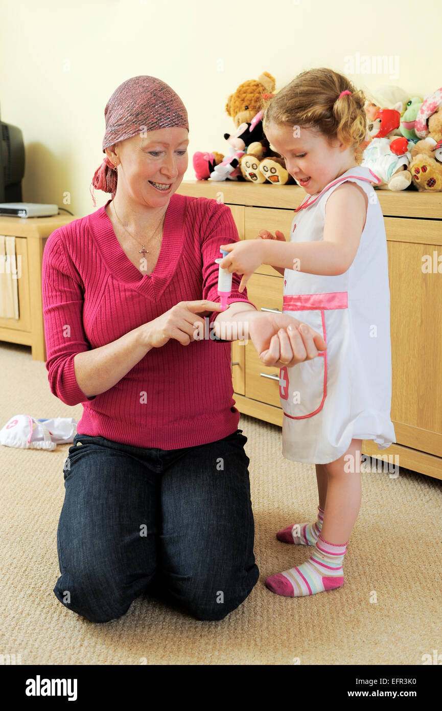Eine Frau benutzt Spiel um zu helfen, ihre Tochter über die Behandlung zu unterrichten, die sie für Krebs. Stockfoto
