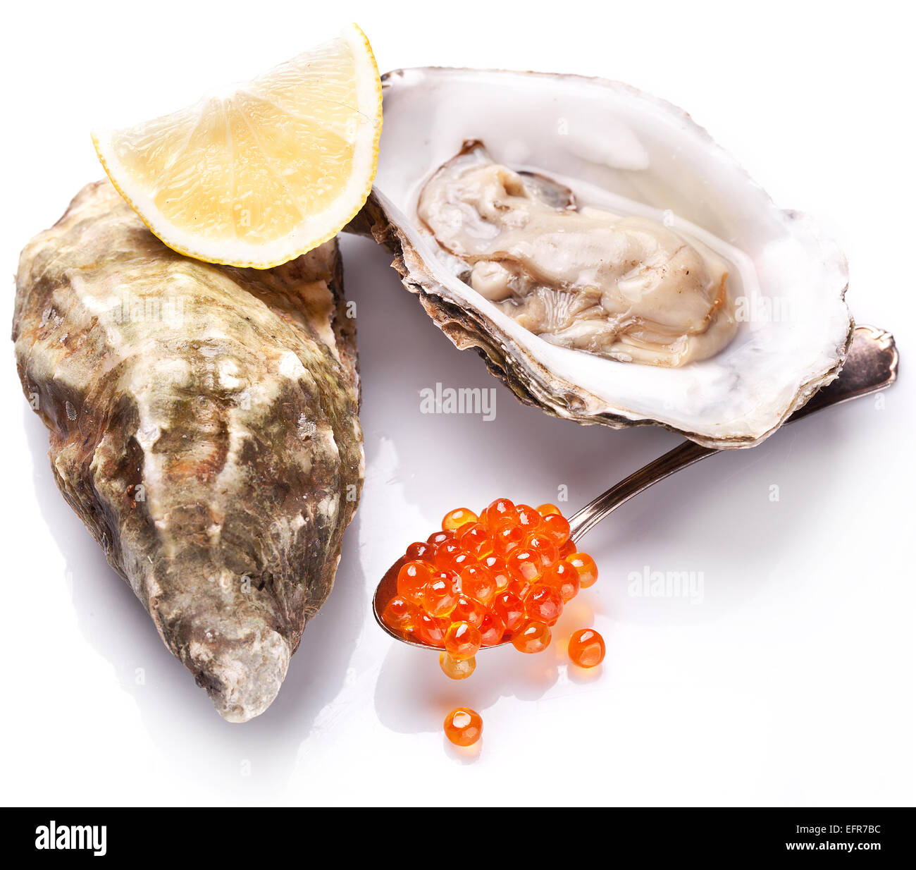 Rohe Austern, Zitronen- und rotem Kaviar auf einem weißen Hintergrund isoliert. Stockfoto