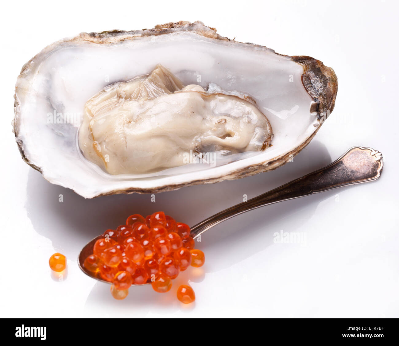 Frisch eröffnet Austern- und silbernen Löffel voll mit Kaviar. Isoliert auf weißem Hintergrund. Stockfoto