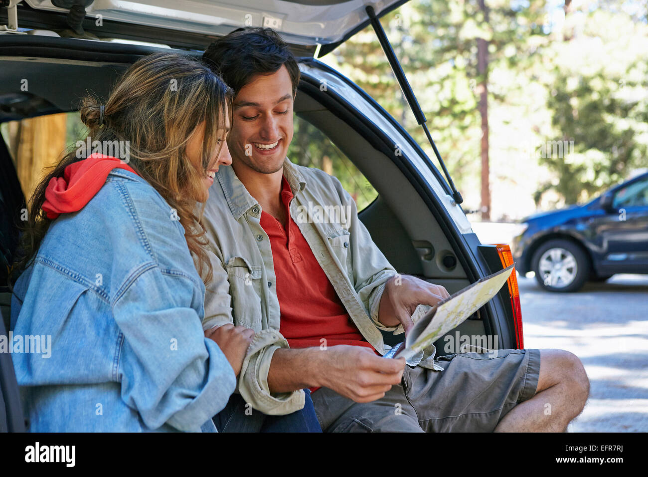 Junges Paar sitzt am Kofferraum Blick auf Karte, Los Angeles, Kalifornien, USA Stockfoto