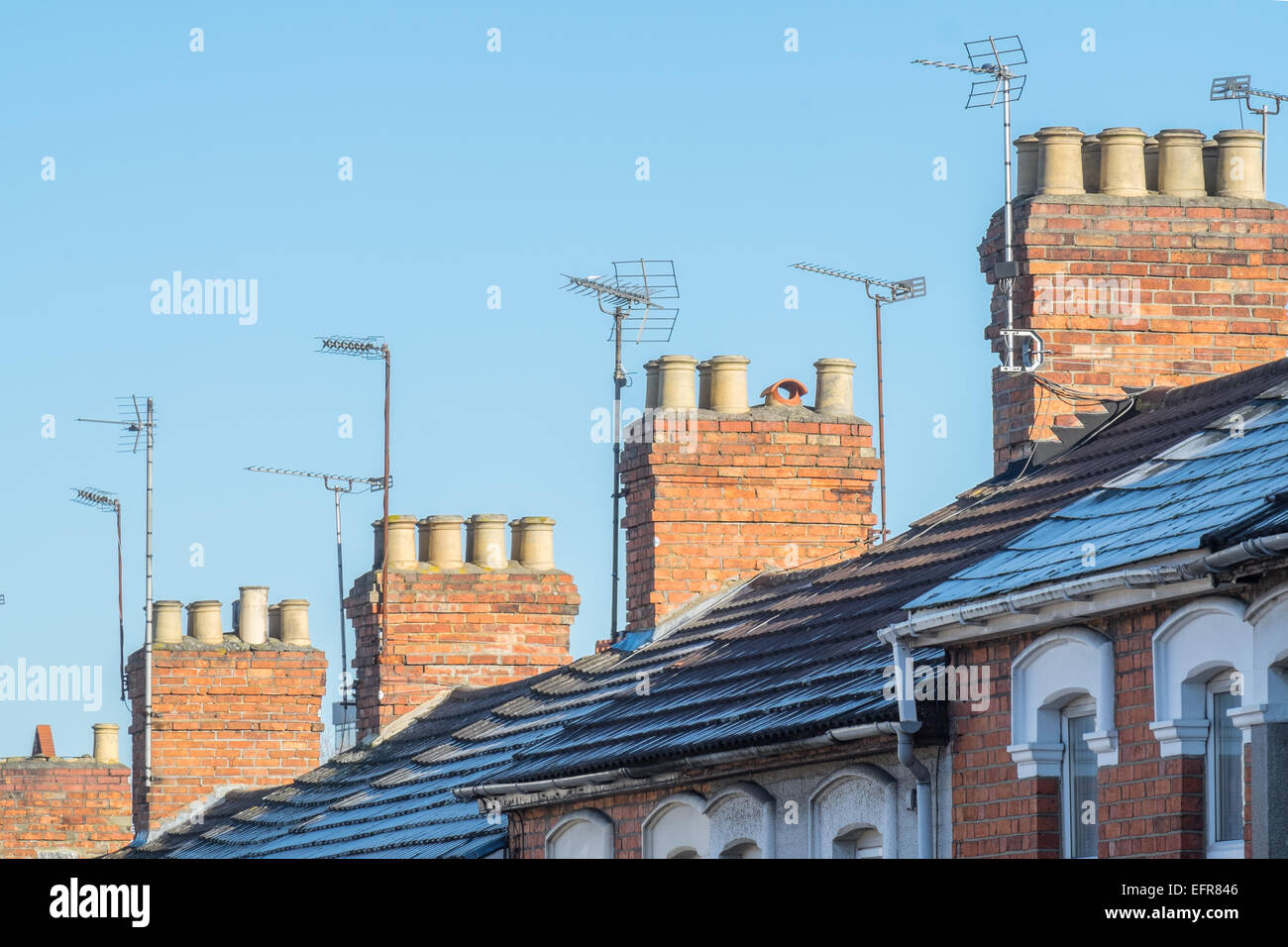 Die Dächer, Schornsteine & Fernsehantennen typisch viktorianischen Reihenhaus Häuser in UK, Suburban Straße an einem klaren Tag Stockfoto