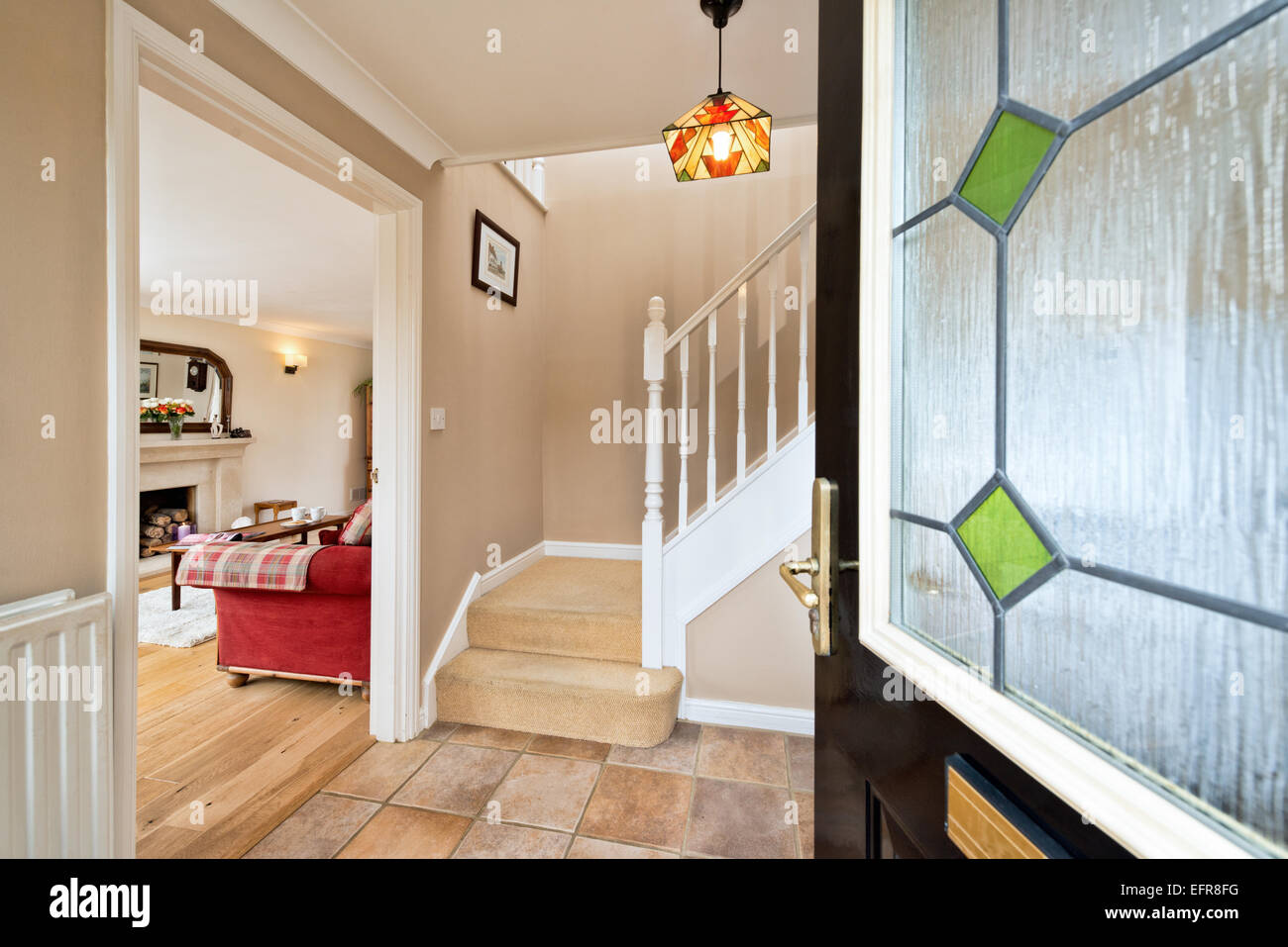 Eine einladende, offene Haustür führt einem typischen, modern, UK-Haus Stockfoto