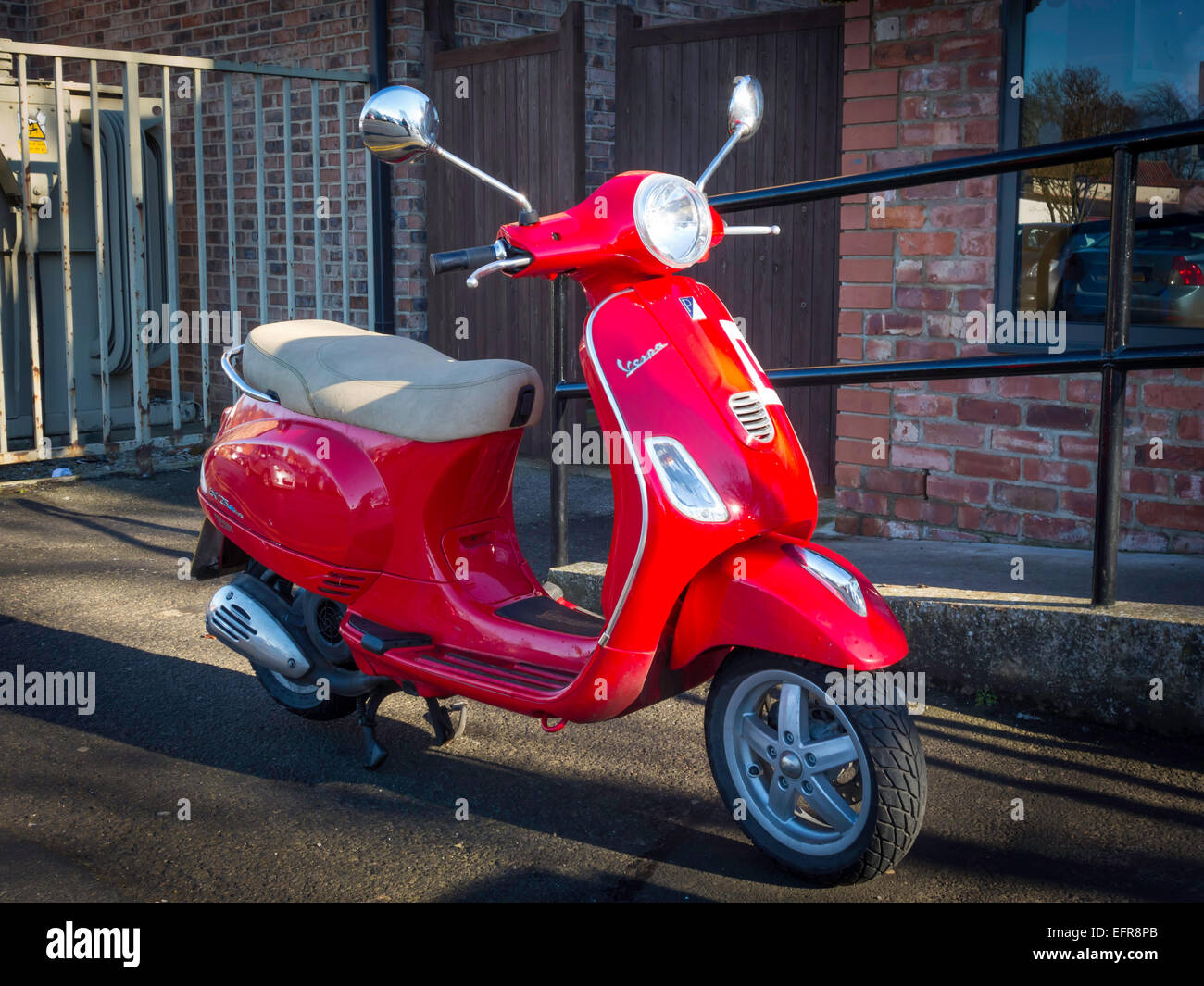 Ein helle rote Vespa Motorroller registriert 2013 Stockfoto