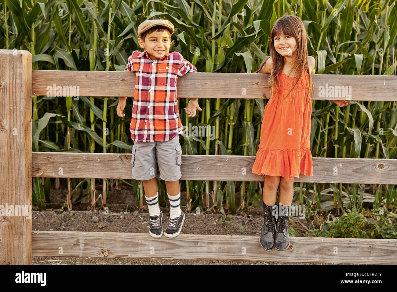 Porträt von jungen und Mädchen stehen und hielt sich an Weidezaun Stockfoto