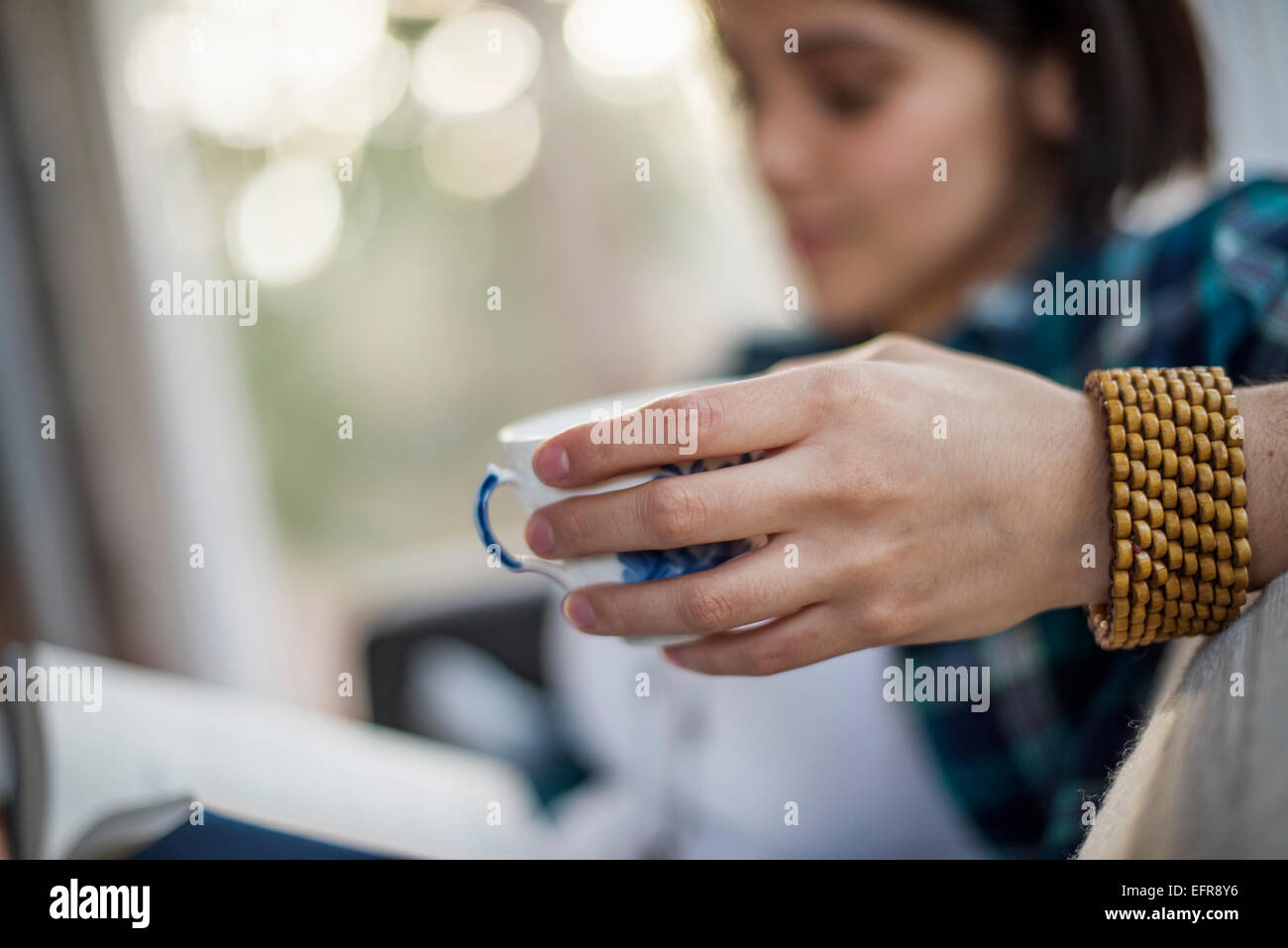 Nahaufnahme einer Frau Hand mit einer Teetasse, eine Armband tragen. Stockfoto