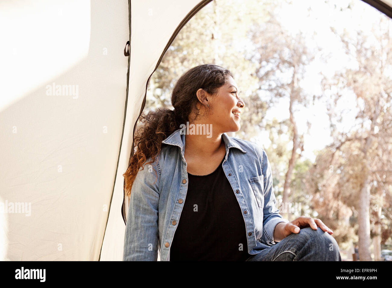 Junge Frau auf der Suche von Zelteingang Stockfoto