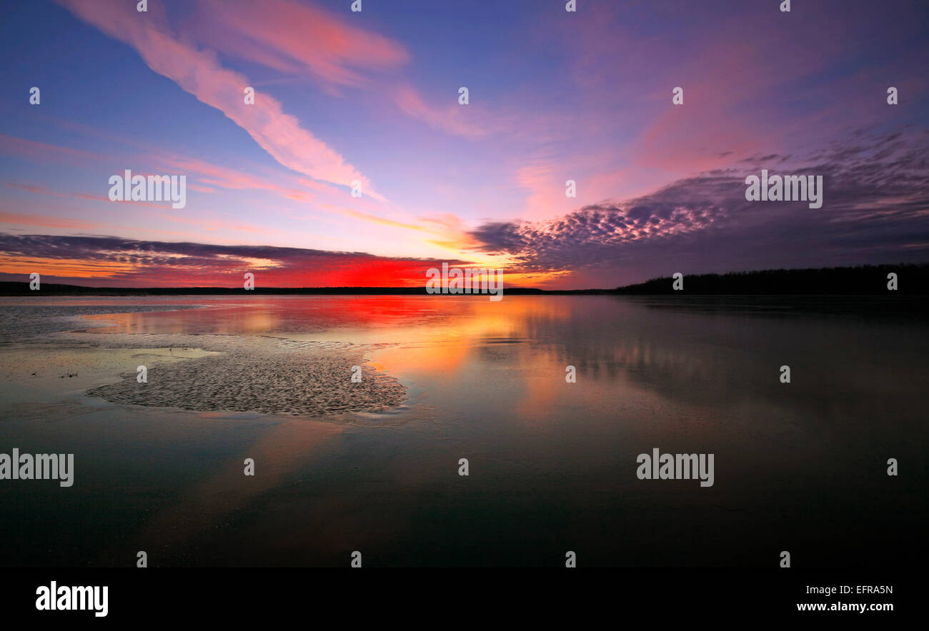 Blick auf den Himmel und Wolken Muster spiegelt sich in der gefrorenen Oberfläche eines Sees. Stockfoto