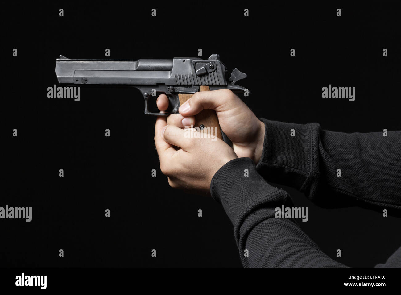 männliche Hände mit Gewehr auf schwarzem Hintergrund isoliert Stockfoto