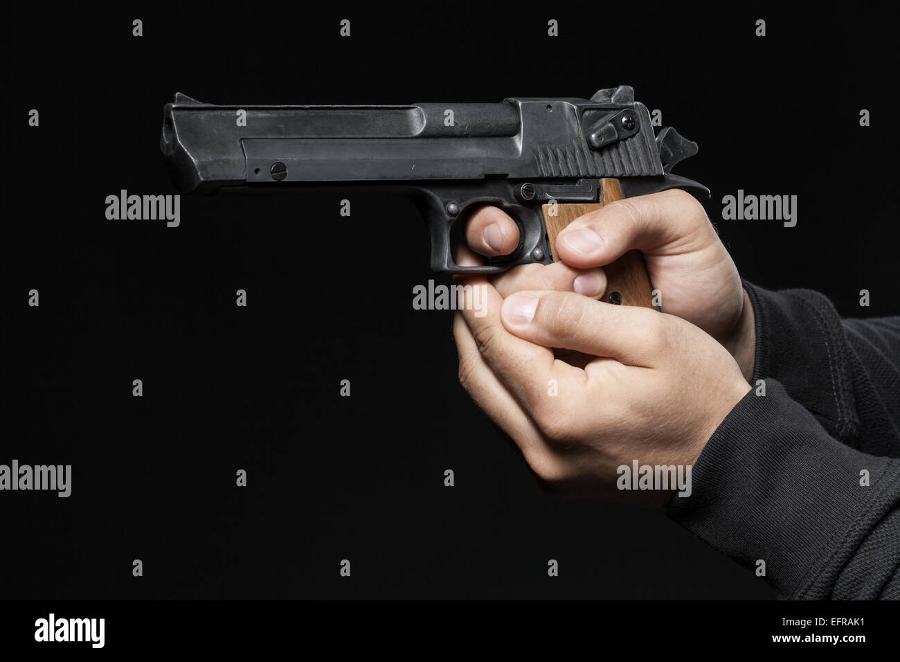 männliche Hände mit Gewehr auf schwarzem Hintergrund isoliert Stockfoto