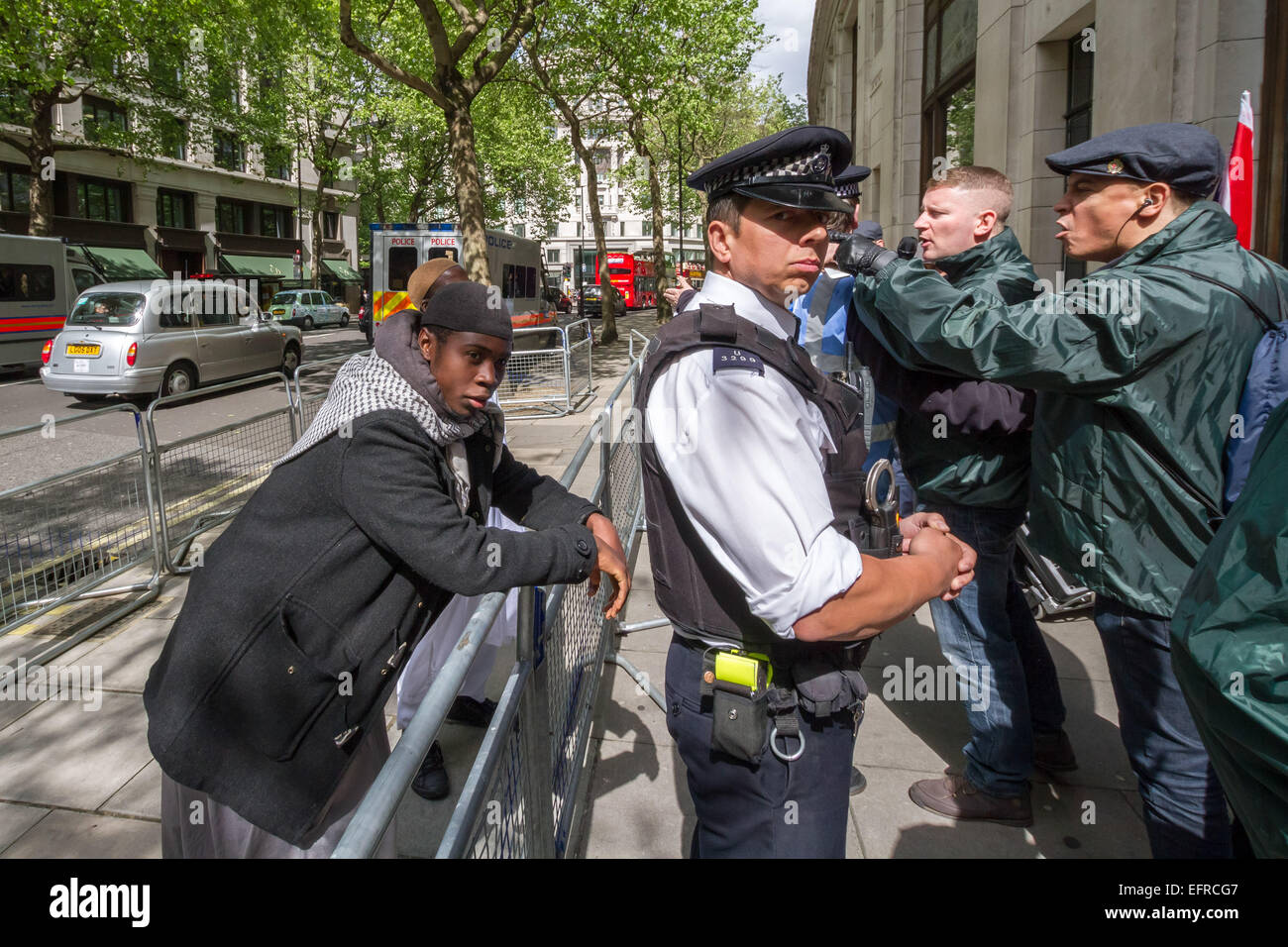 Brustchom Ziamani (L) am 9. Mai 2014 vor dem indischen Hochkommissar in London während eines islamistischen Protestes mit britischen First Nationalists, darunter Paul Golding Opposing (R). Brustchom Ziamani, 19, wurde in Gewahrsam genommen, nachdem er vor Gericht erschienen war, um Terroranschuldigungen zu begegnen. Ziamani aus Camberwell im Südosten Londons wurde beschuldigt, am oder vor dem 19. August 2014 "an der Vorbereitung von Terroranschlägen zu arbeiten". Herr Ziamani wurde am Dienstag, den 19. August 2014 in Ost-London verhaftet. Er befindet sich derzeit vor Gericht in Old Bailey. Stockfoto