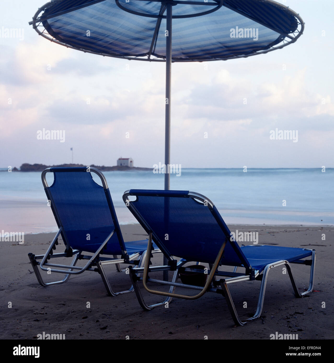 Zwei am Strand liegen und Sonnenschirm am Strand an einem Vormittag Stockfoto