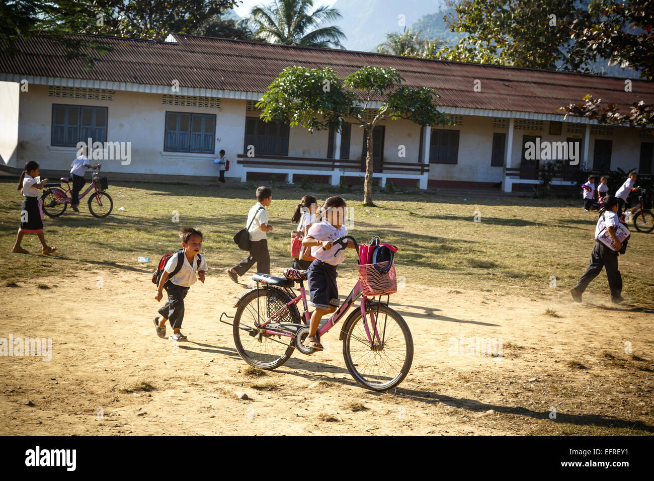 Schülerinnen und Schüler Reiten eines Fahrrades, Vang Vieng, Laos. Stockfoto