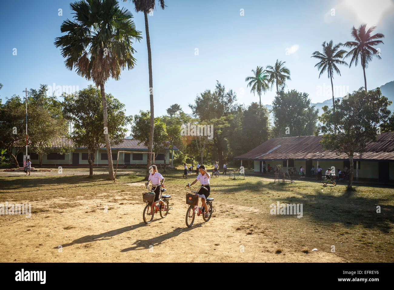 Schülerinnen und Schüler Reiten eines Fahrrades, Vang Vieng, Laos. Stockfoto