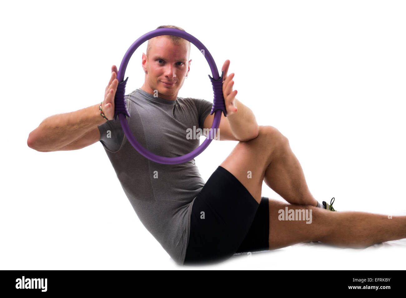 Attraktive sportliche junge Mann arbeiten mit Pilates ring Stockfoto