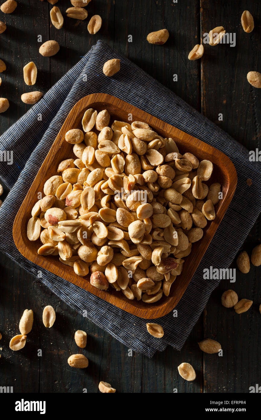 Bio geröstete salzige Erdnüsse in eine Schüssel geben Stockfoto