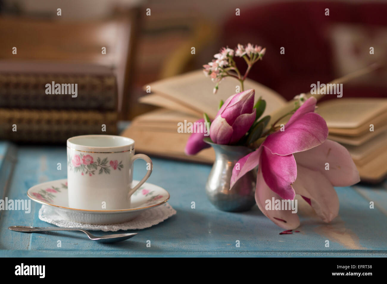 Ein ziemlich Kaffeetasse und ein aufgeschlagenes Buch auf einem Holztisch Stockfoto