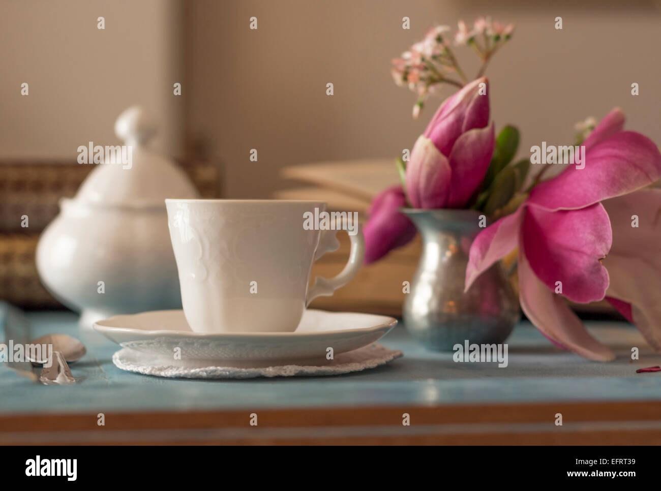 Ein ziemlich Kaffeetasse und ein aufgeschlagenes Buch auf einem Holztisch Stockfoto