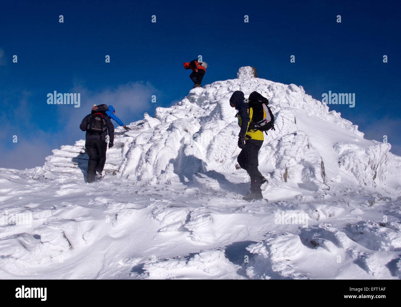 Wanderer auf dem Gipfel des Snowdon, dem höchsten Berg in England und Wales, im Winter Stockfoto