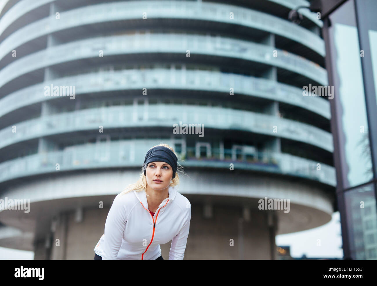Sportler haben eine kurze Pause vom laufen. Junges Weibchen auf Stadtstraße auszuüben. Stockfoto