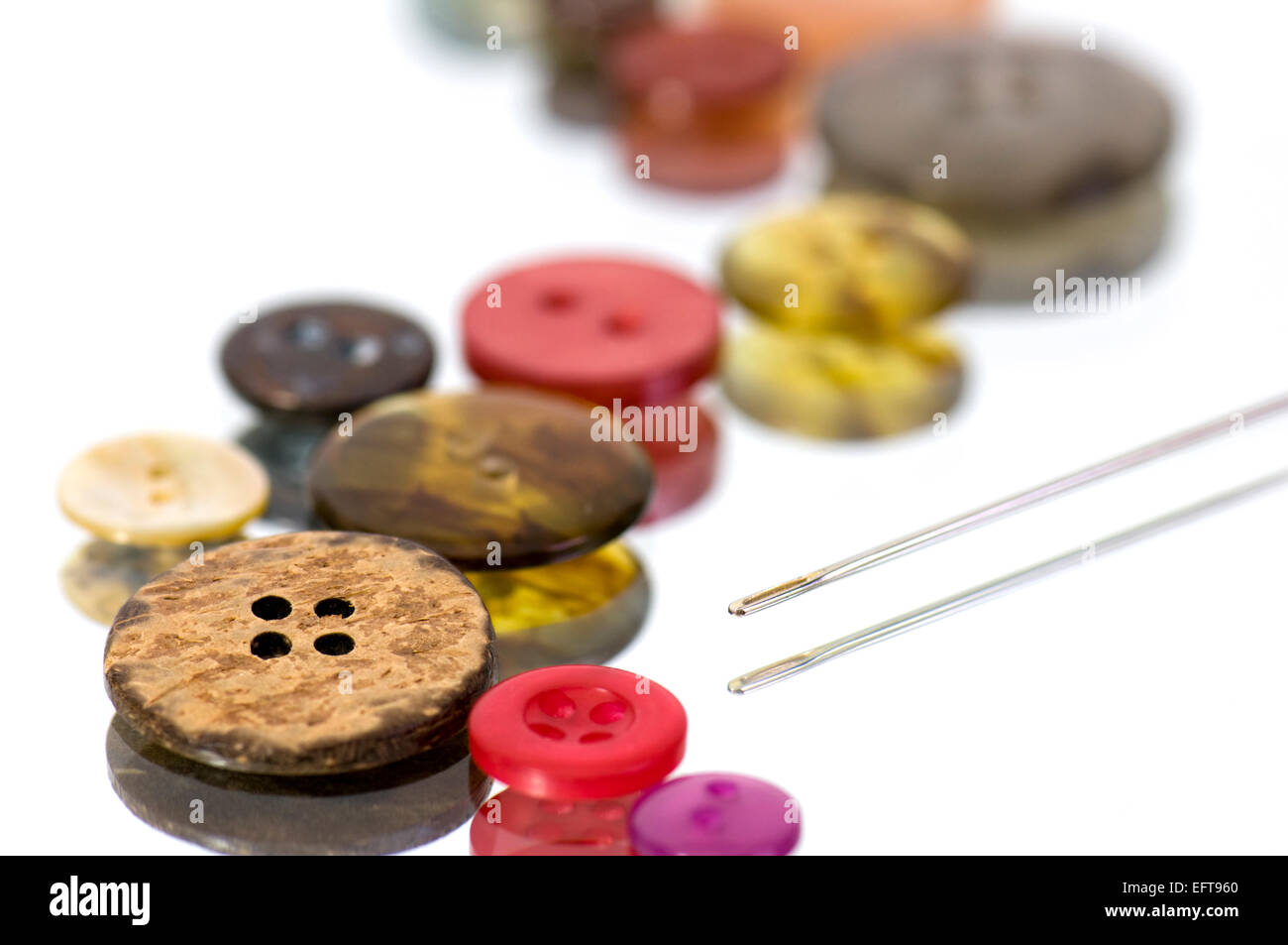 Nahaufnahme von Multi-farbigen Tasten und Nadel auf reflektierende Oberfläche Stockfoto