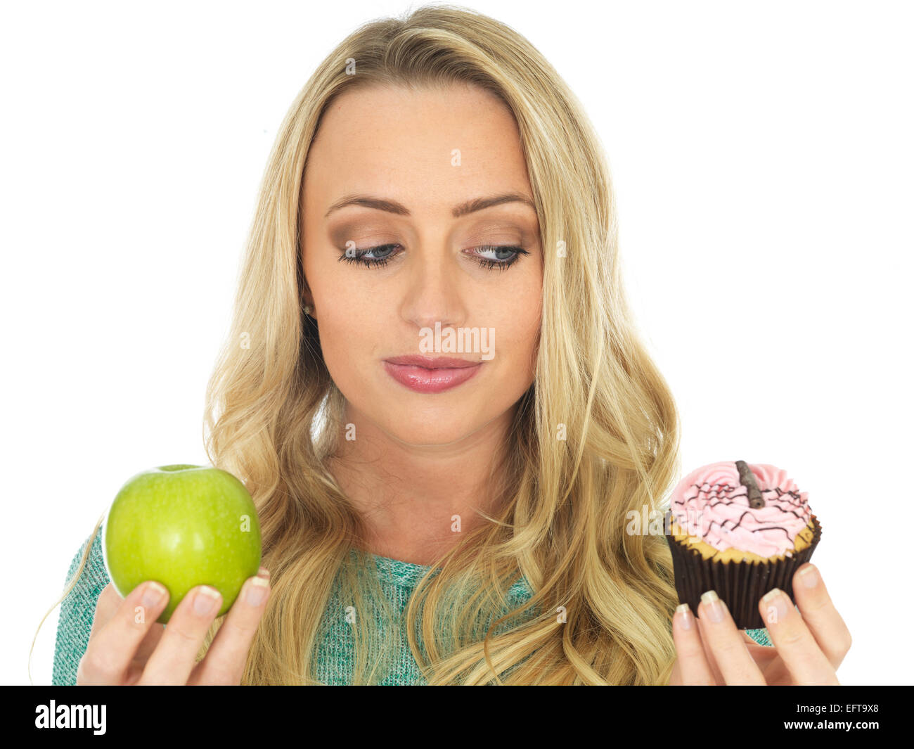 Junge Frau mit und Vergleichen von Kuchen und Obst Stockfoto
