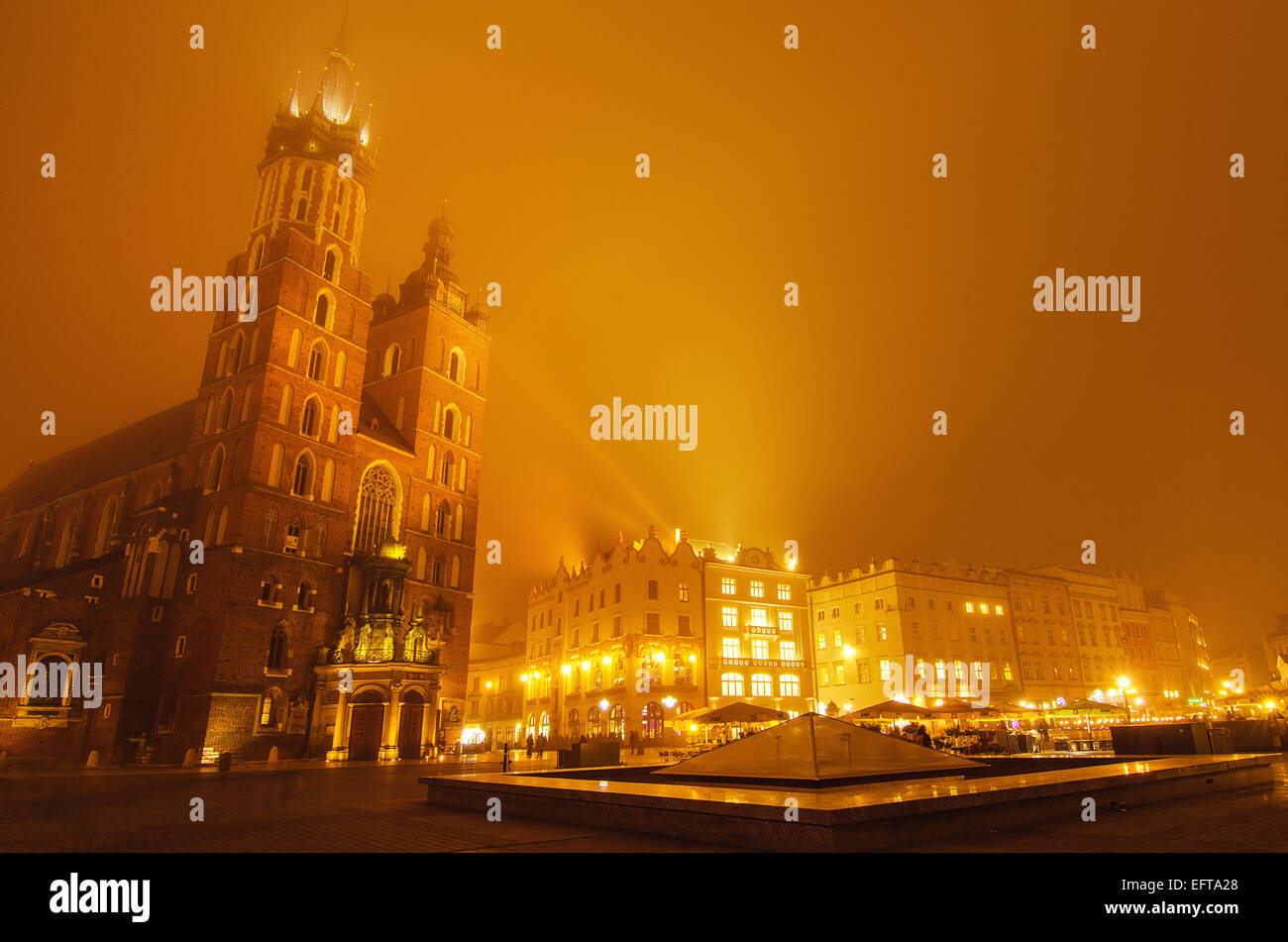 Marktplatz in Krakau in der nebligen Nacht mit der Marienkirche mit goldenen Himmel Stockfoto