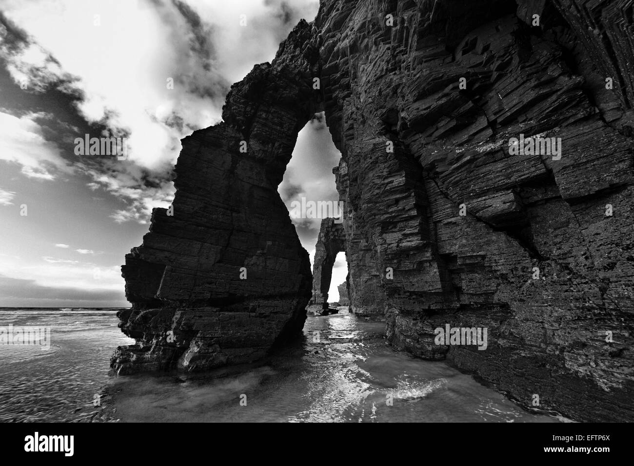 Spanien, Galicien: Rock-Bögen auf ansehnliche Strand in schwarz / weiß-version Stockfoto