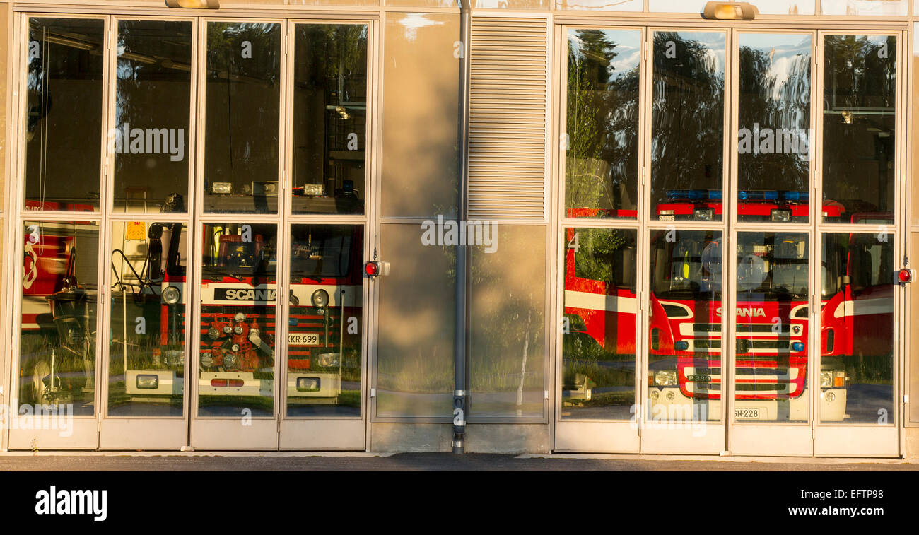 Feuerwehrautos hinter Glastüren in der Feuerwache Garage, Finnland Stockfoto