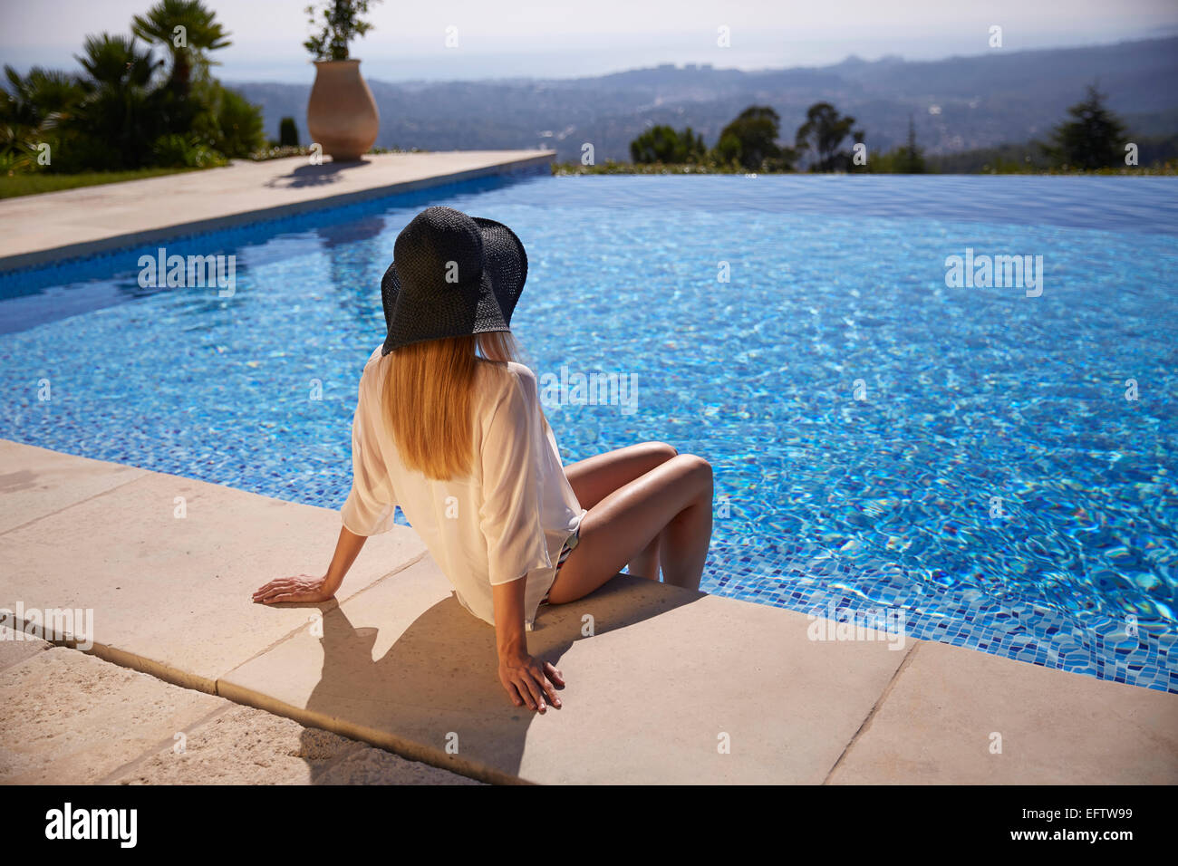 Junge Frau sitzt am Pool im Urlaub in Südfrankreich Stockfoto