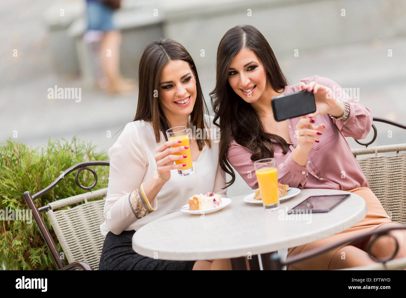 Junge Frauen, die Fotos mit dem Handy im café Stockfoto