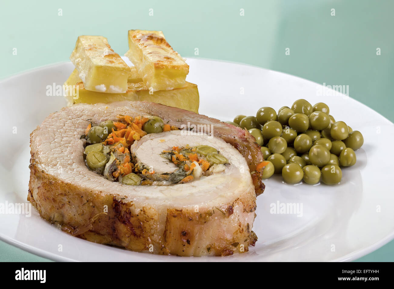 Nahaufnahme der Heimat Hackbraten mit Bratkartoffeln und grünen Erbsen. Stockfoto