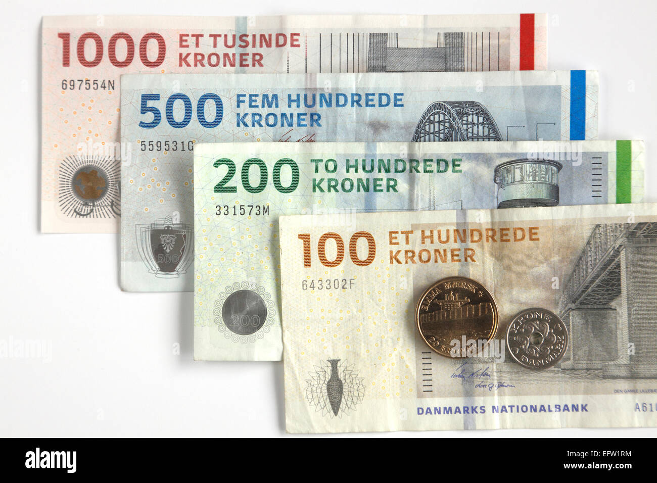Dänische Währung auf weiß. Banknoten von Kroner 1000, 500, 200 und 100- und ein 20 Kronen Stück und 1 Kronen Stück Stockfoto