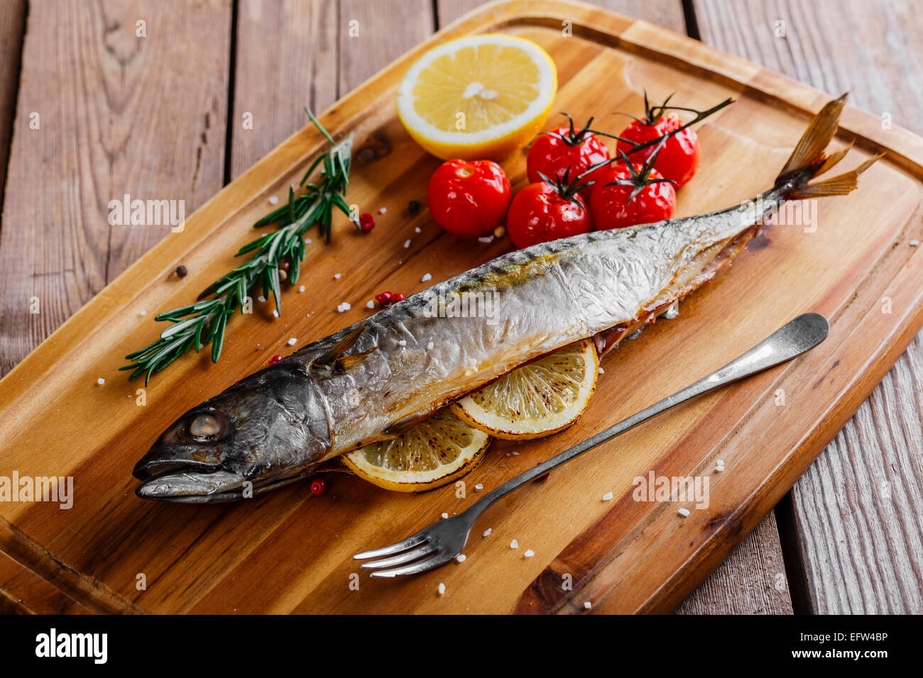 gebackener Fisch Makrele ganz mit Zitrone und Tomaten Stockfoto