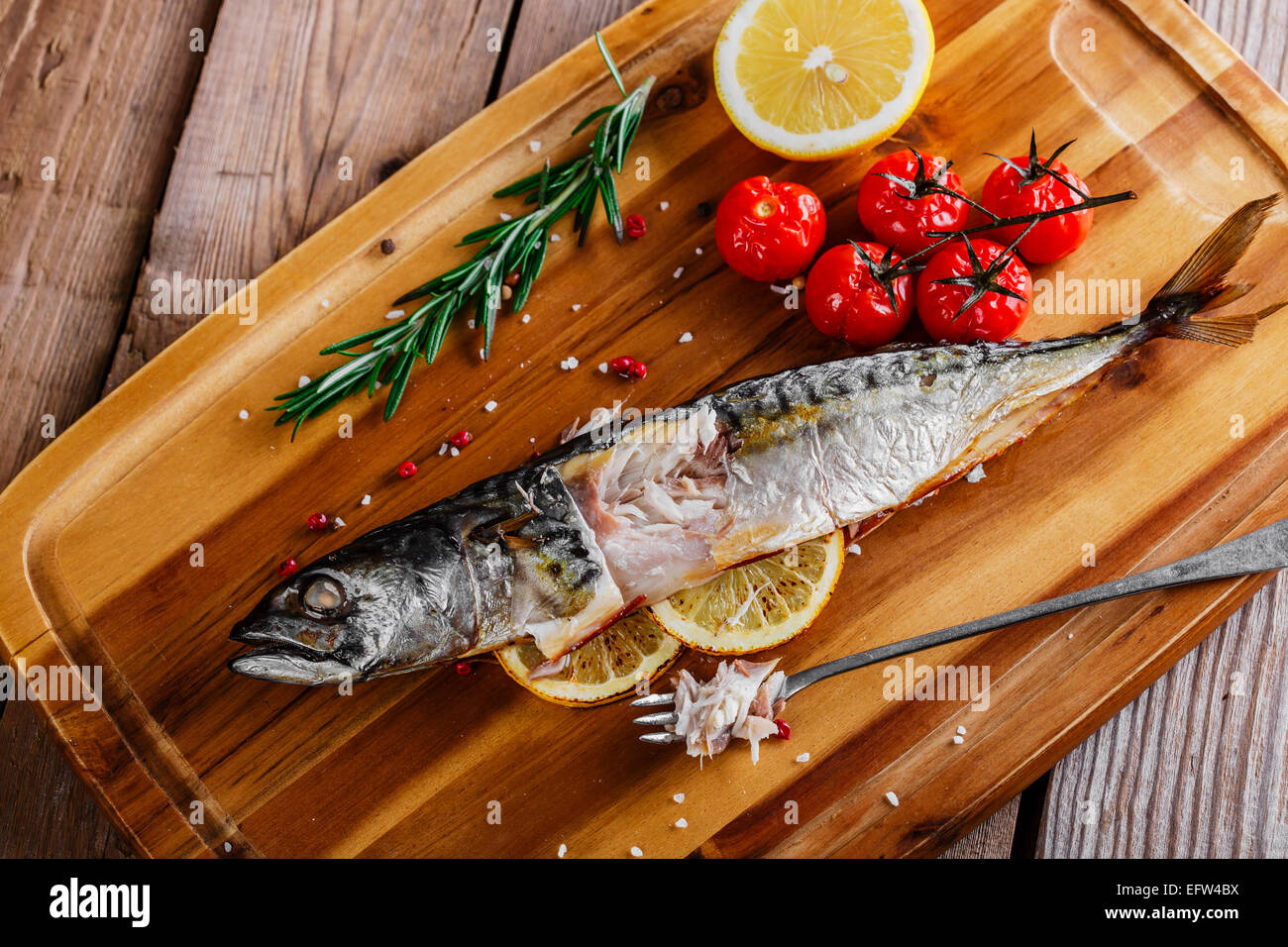 gebackener Fisch Makrele ganz mit Zitrone und Tomaten Stockfoto