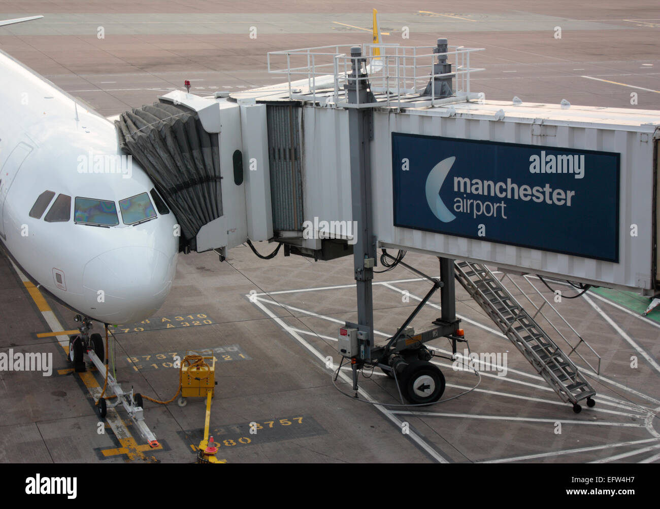 Der Zivilluftfahrt. Gewerblichen Luftverkehr. Pkw Flugzeug zu seinen jetbridge auf der Rampe oder Schürze auf dem Flughafen Manchester, UK angeschlossen Stockfoto