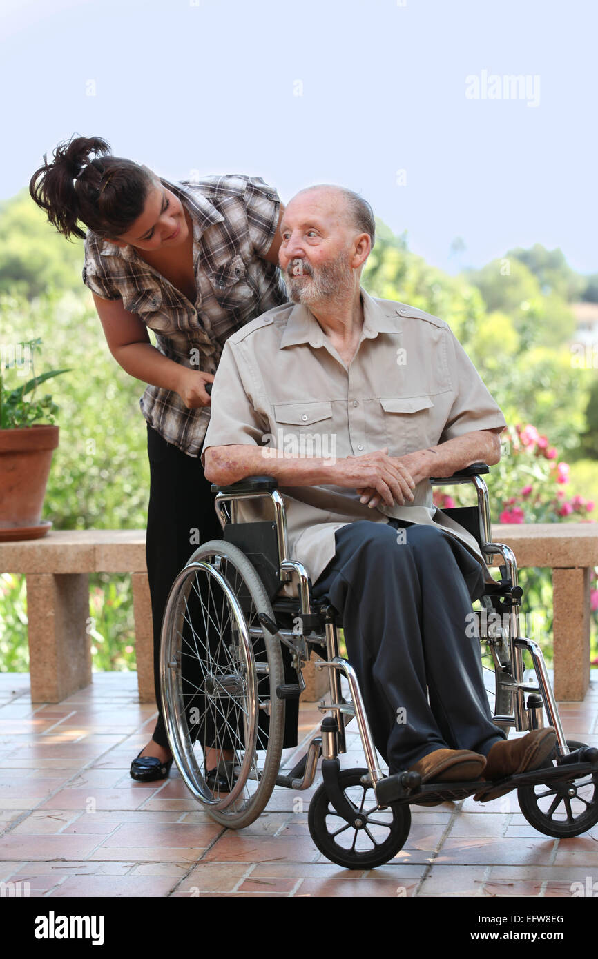 älterer Mann, Spaziergang im Rollstuhl mit Enkelkind Stockfoto